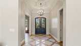 Double Entry Front Door Leads to Foyer with Coffered Ceiling